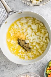 menambahkan bumbu pada mentega cair dan bawang bombay untuk membuat Chicken Pot Pie Casserole
