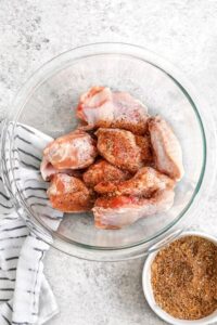 menambahkan bumbu pada sayap ayam untuk membuat Sayap Ayam Gosok Kering