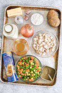mentega, susu, bawang putih, tepung terigu, kentang, bawang merah, kaldu, sayuran, biskuit dan bumbu berlabel untuk membuat Chicken Pot Pie Casserole