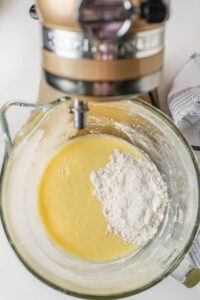 menambahkan tepung ke mangkuk untuk membuat Lemon Pound Cake