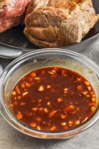 saus dengan daging babi yang dimasak dalam wajan untuk menunjukkan cara membuat Sandwich Babi Tarik Slow Cooker