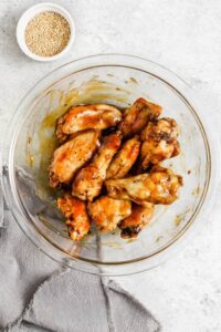 menambahkan saus ke sayap untuk membuat Sayap Ayam Teriyaki