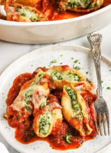 plated Classic Stuffed Shells Recipe with dish full in the background