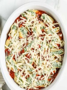 adding cheese to Classic Stuffed Shells Recipe