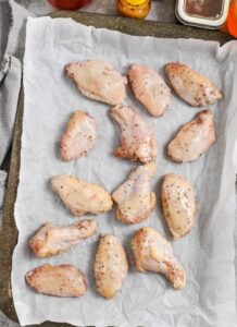 menuangkan madu panas ke atas Honey Hot Wings yang sudah dilapisi