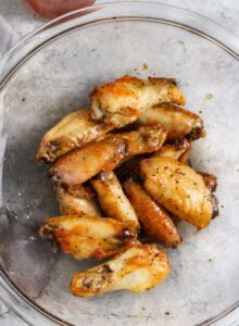 melapisi sayap ayam dengan saus untuk membuat Sayap Panas Madu