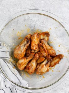 Sayap Mangga Habanero yang dimasak dicampur dengan saus dalam mangkuk