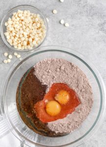 menambahkan telur dan minyak ke dalam campuran kue untuk membuat Kue Campuran Kue Red Velvet