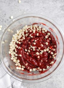 menambahkan keping coklat ke dalam mangkuk untuk membuat Kue Campuran Kue Red Velvet