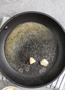 menambahkan bumbu ke mentega untuk membuat Sayap Garam dan Cuka